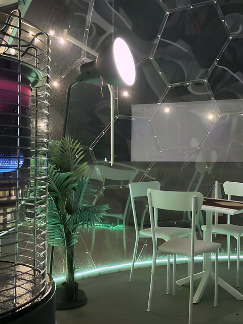 Interno di una bolla con illuminazione verde e tavoli